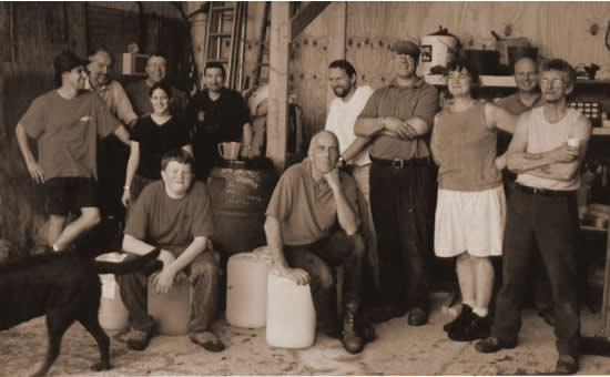The first year's team pose for a photo around the barrels containing our first juice